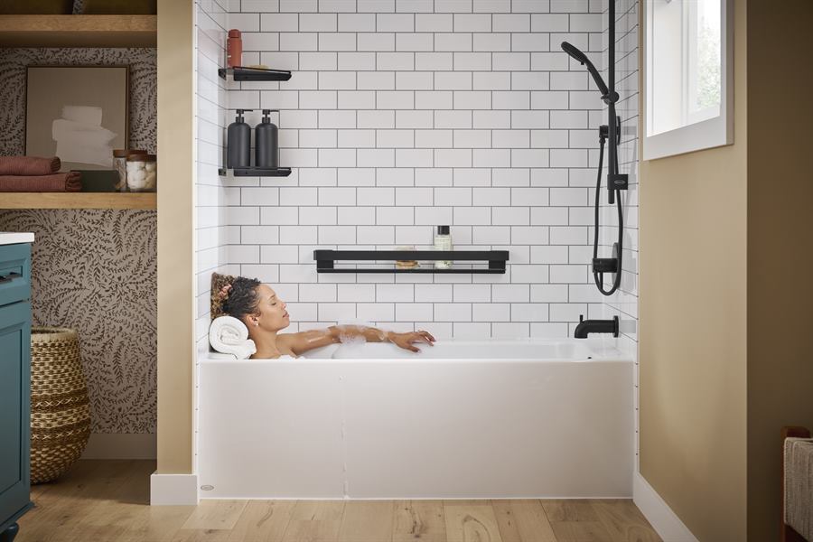 Homeowner relaxing in a new bathtub with subway-tile wall surround